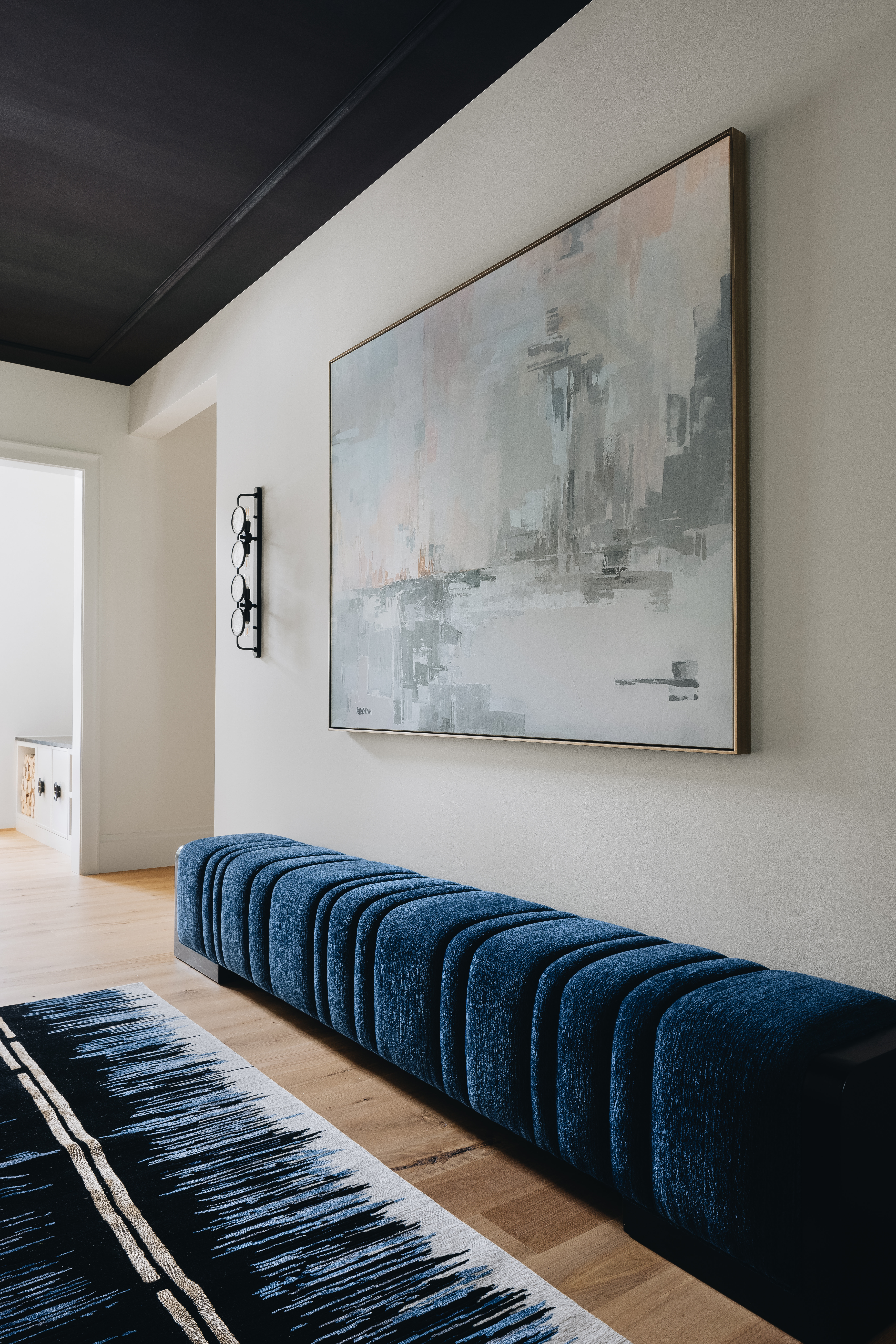 Gallery-like hallway with blue upholstered bench